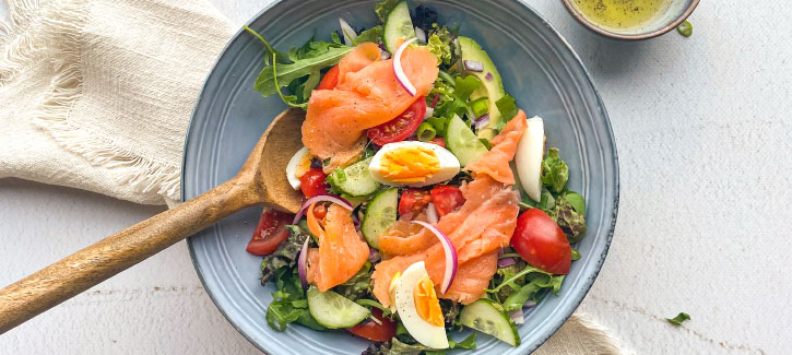 Salat mit geräuchertem Lachs, Ei, Tomaten und Gurke
