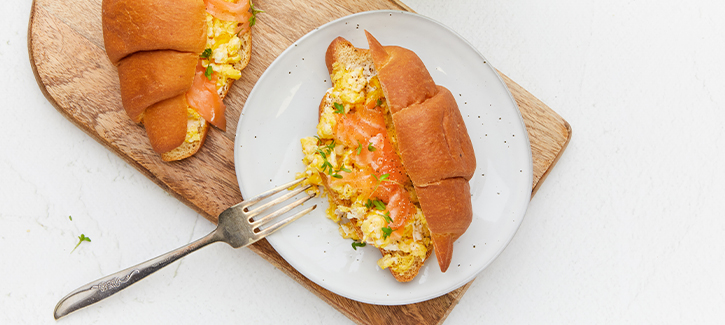 Croissant mit Rührei und Lachs