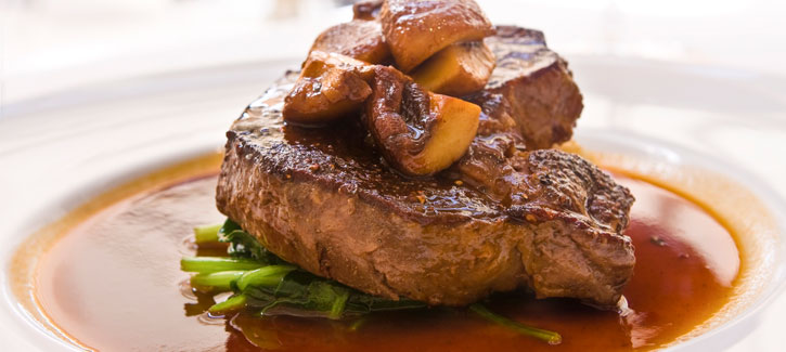 Steak mit Champignons auf einem Bett aus Spinat